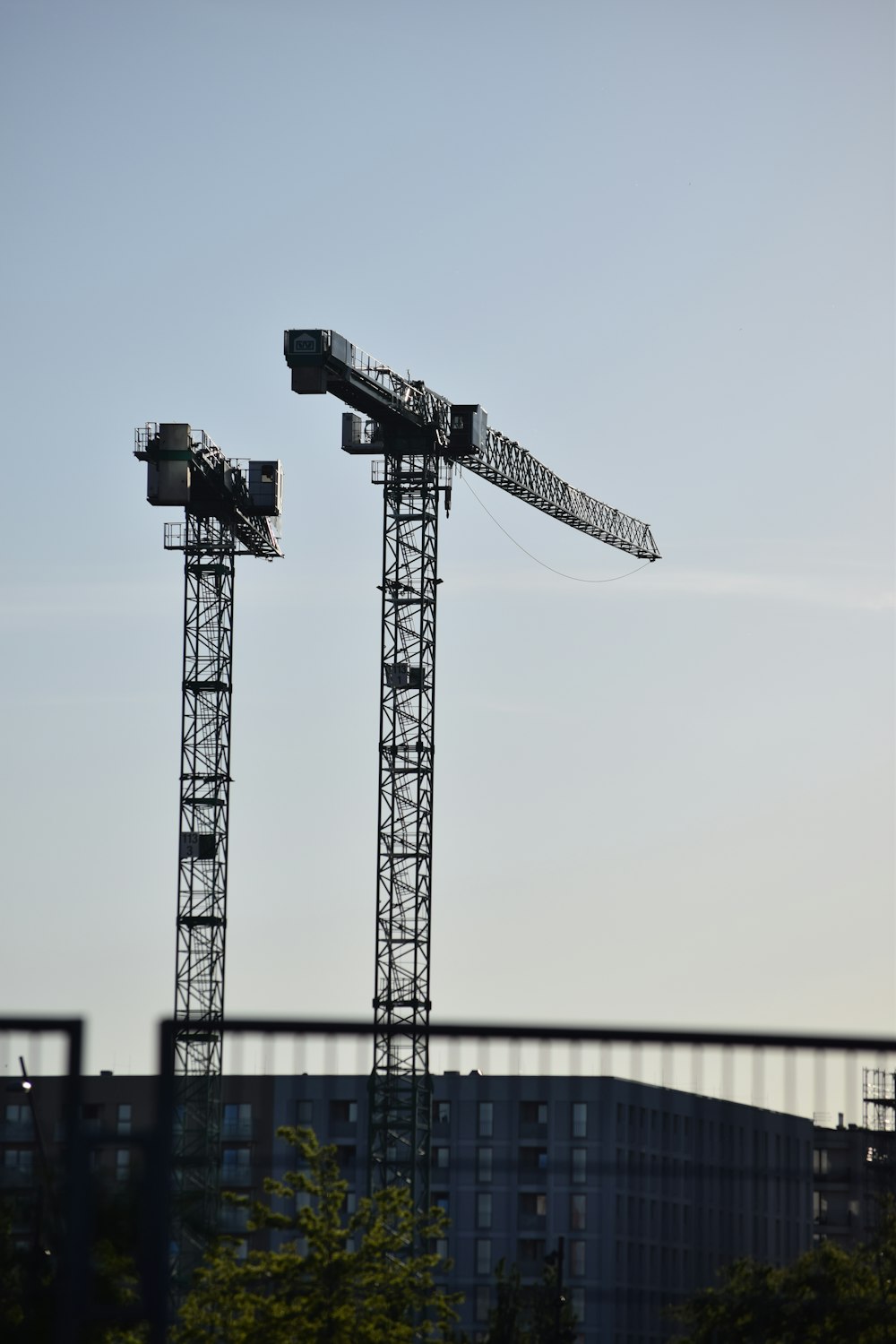 a couple of cranes that are next to a building