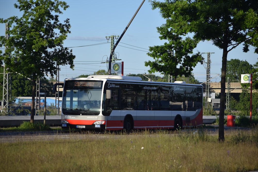 a red and white bus driving down a street