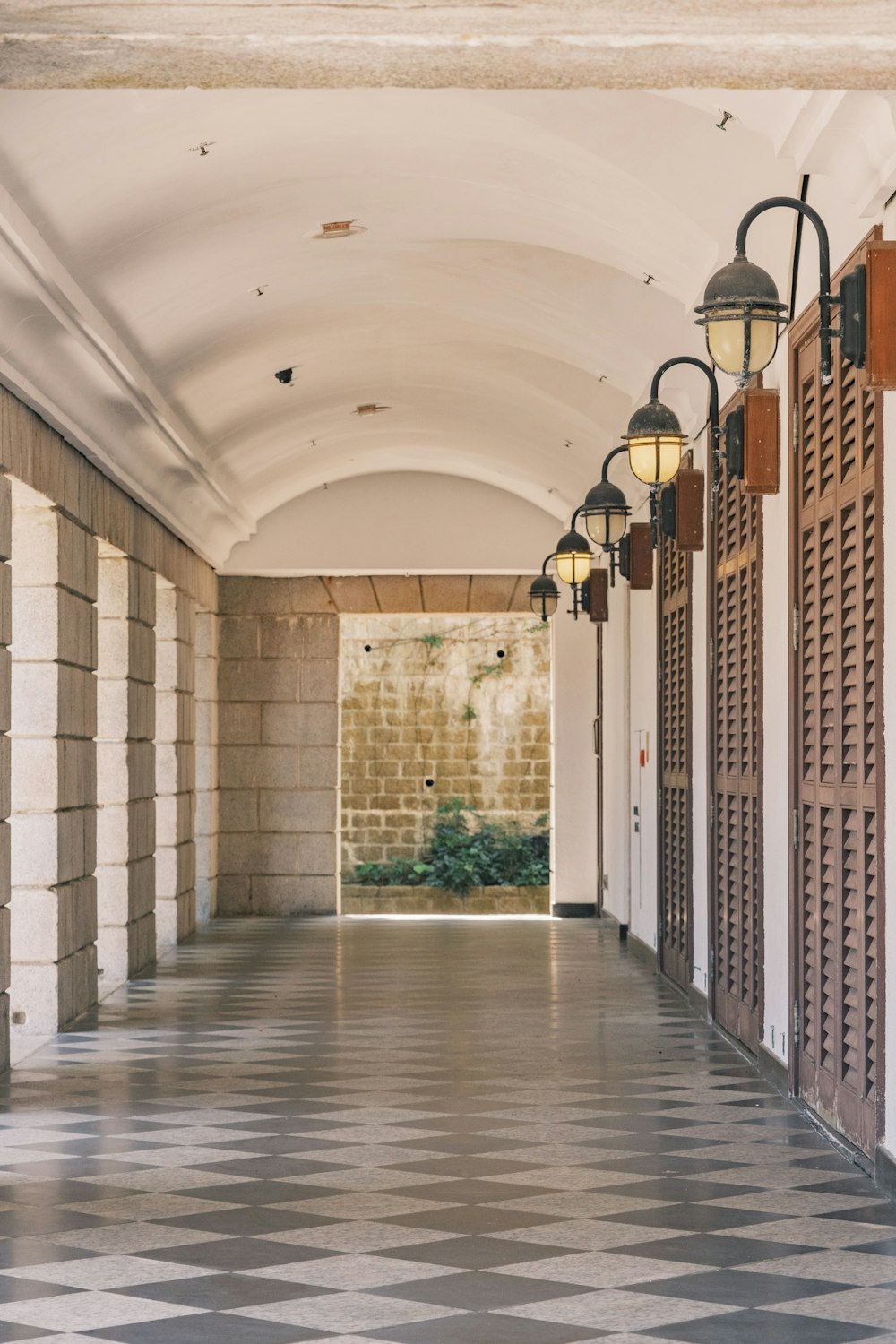 a long hallway with a checkered floor and light fixtures
