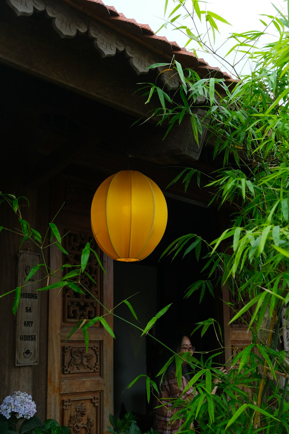 a yellow lantern hanging from the side of a building