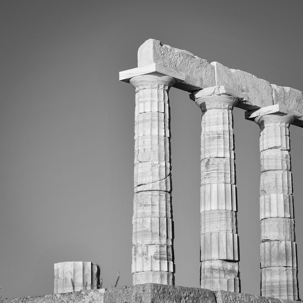 a black and white photo of three stone pillars