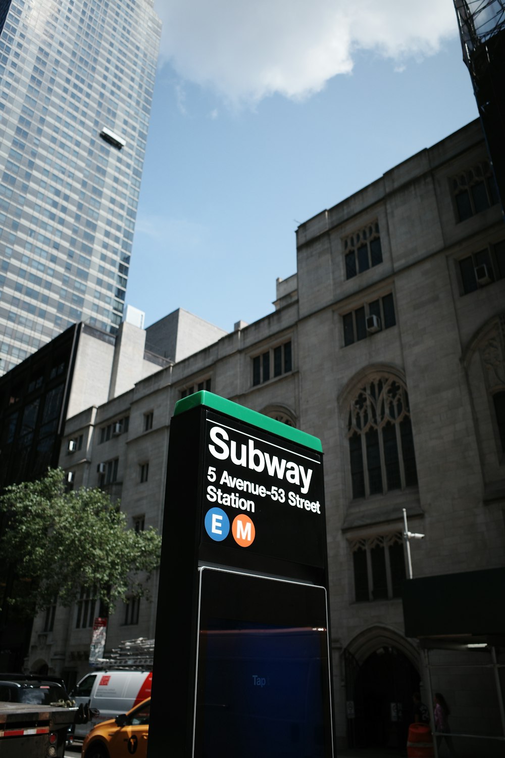 a subway sign in front of a tall building