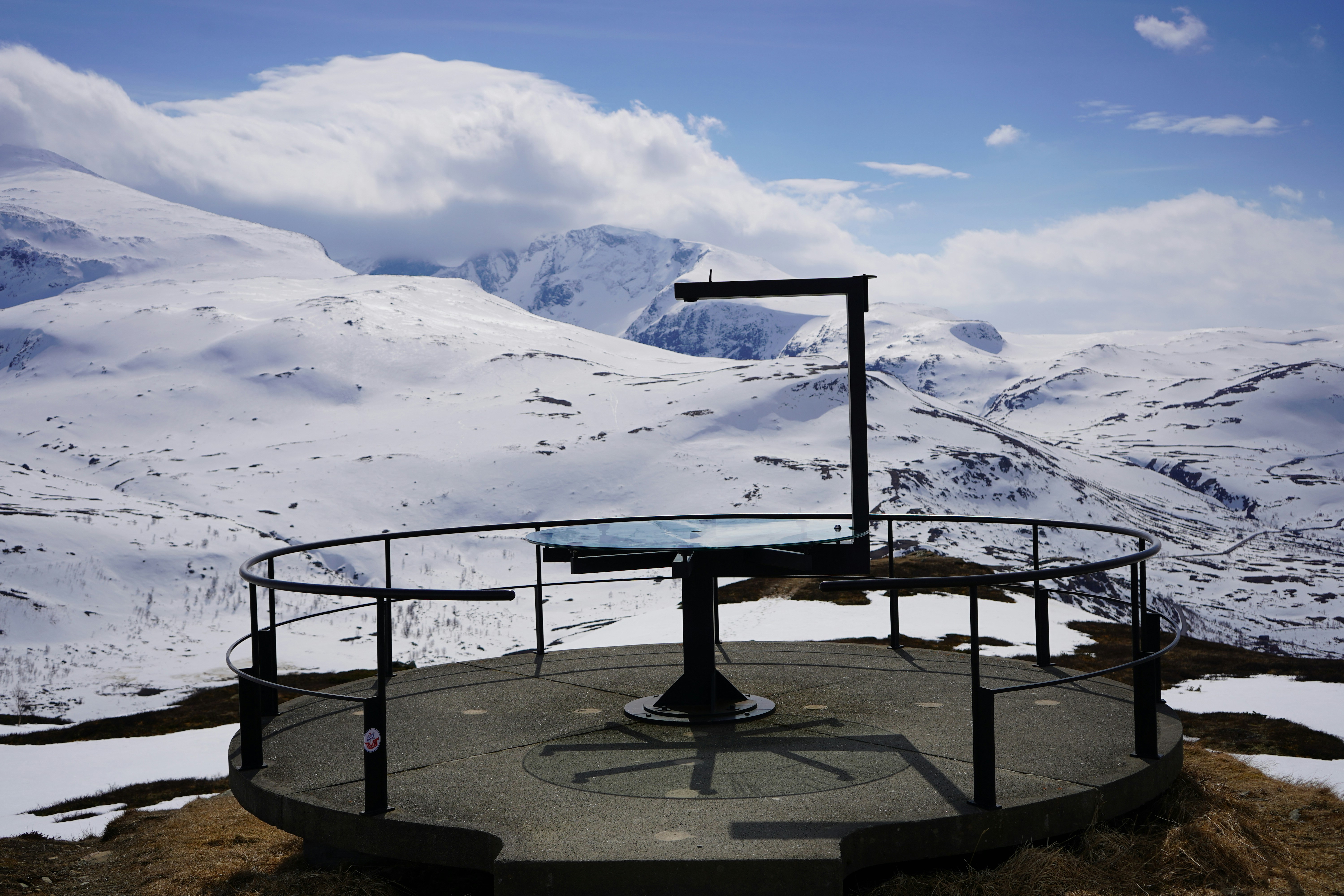 a round table with a glass top on top of a snow covered mountain