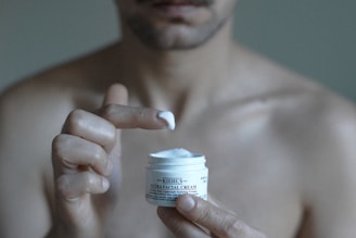 a man holding a jar of cream in his hand