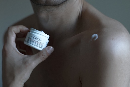 a man holding a jar of cream in his hand