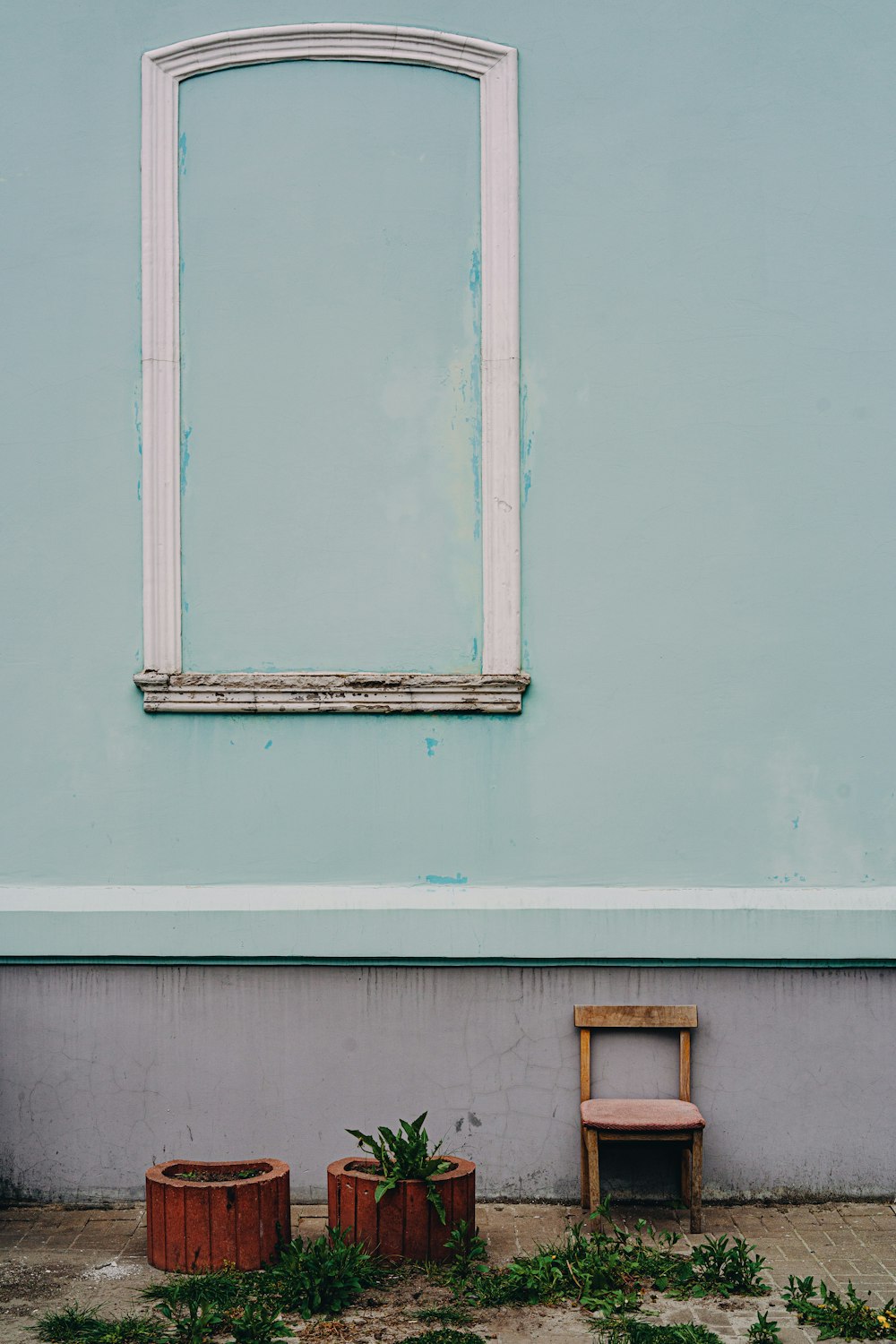 a blue wall with a window and a chair