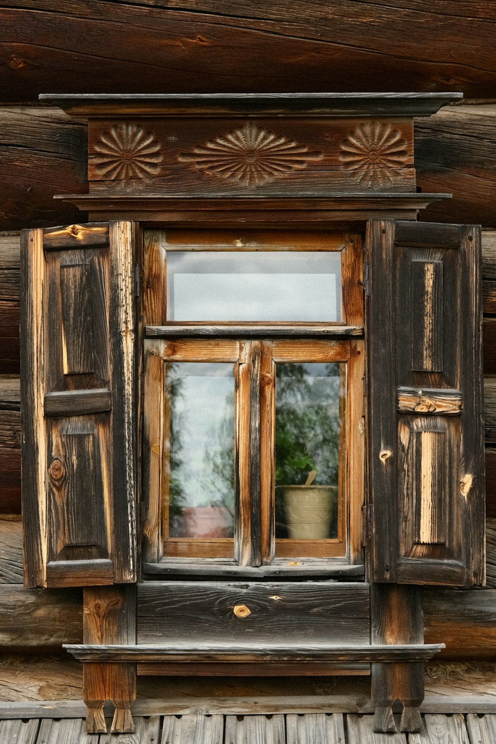 a wooden window with a potted plant in it