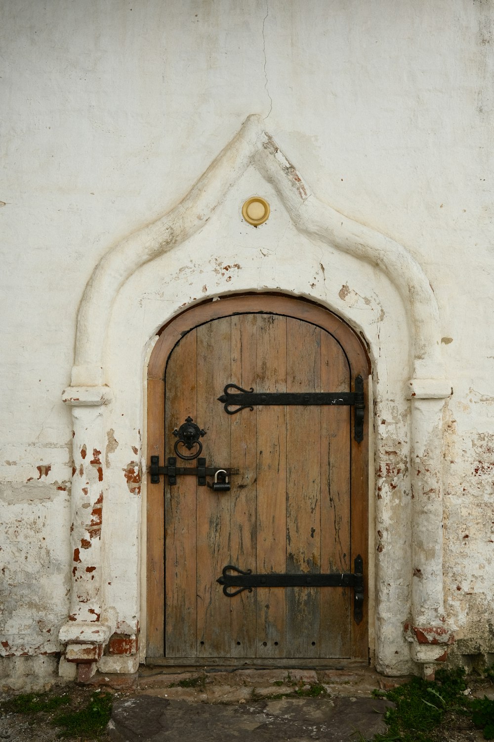 a wooden door in a white stucco wall