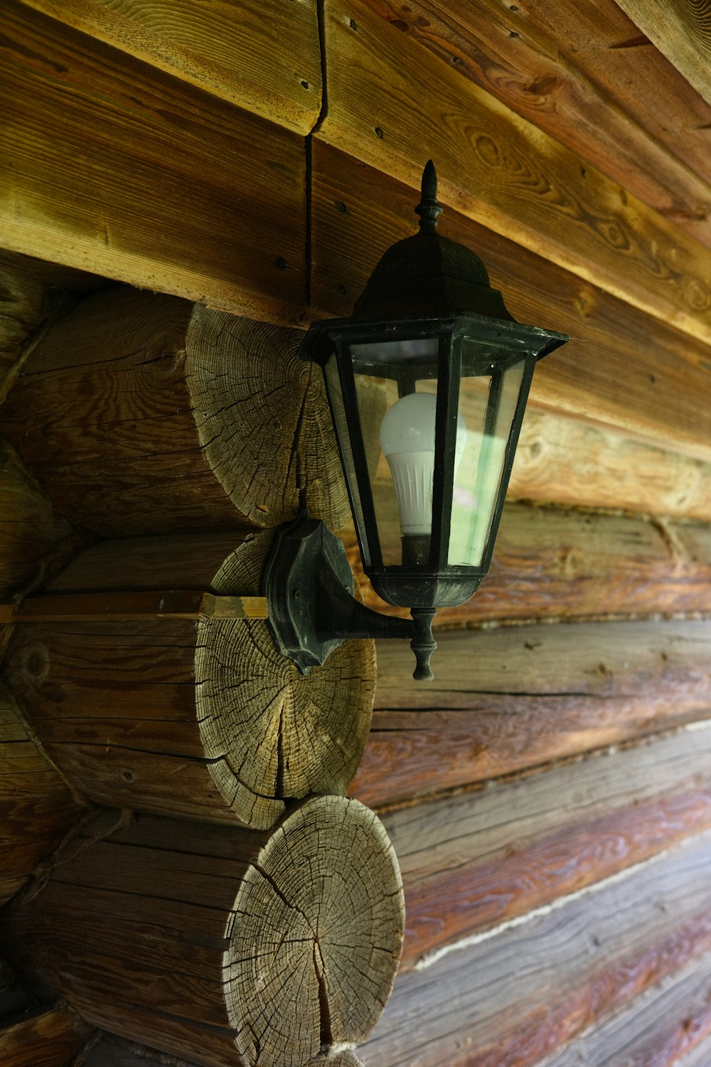 a lantern hanging from the ceiling of a log cabin