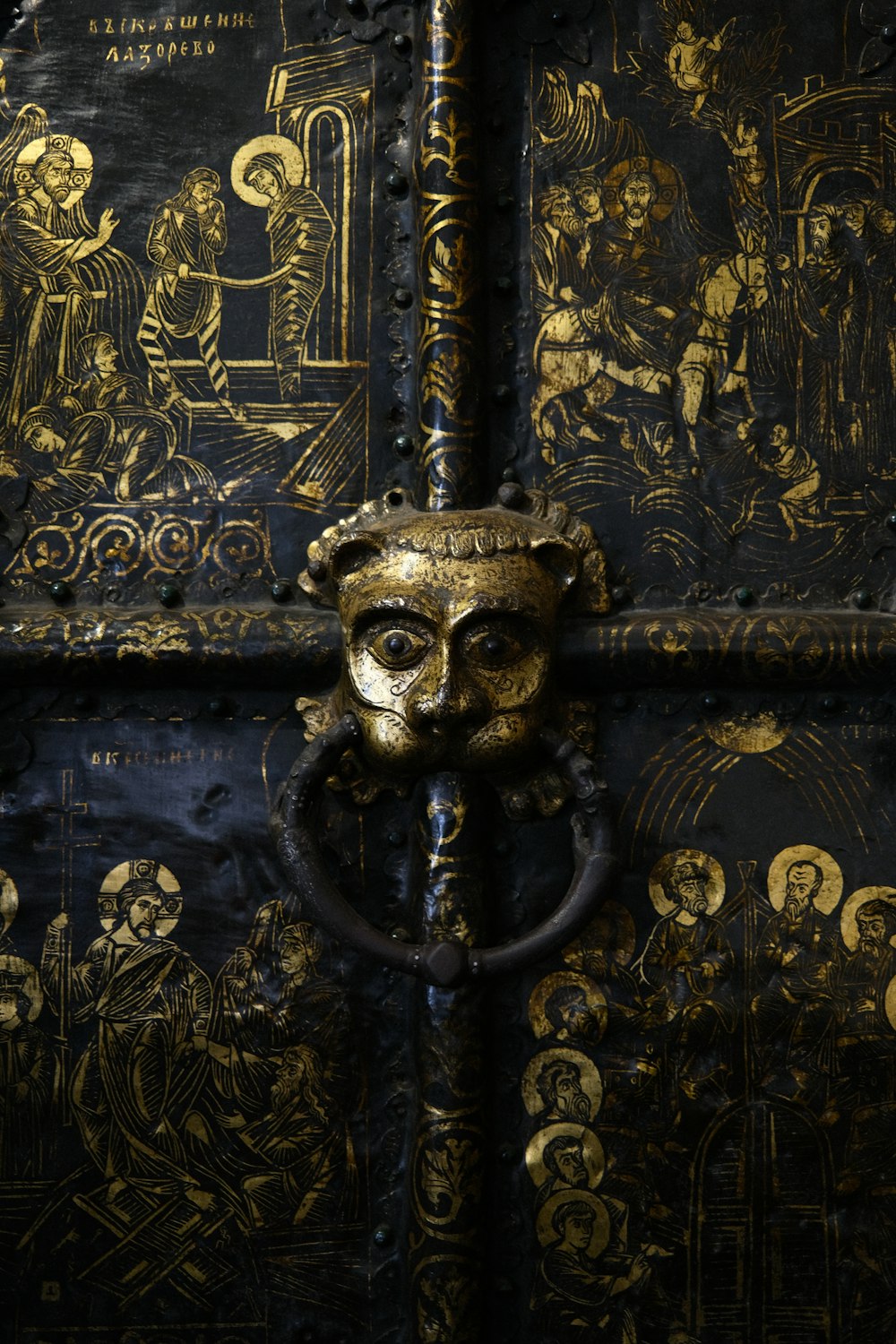 a close up of a metal door with gold designs on it