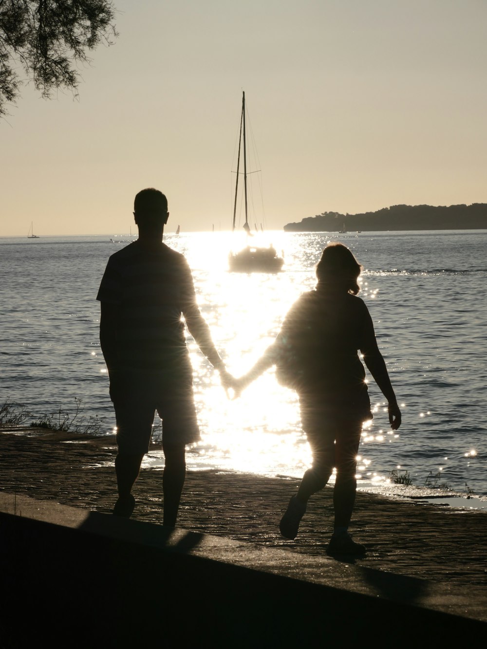 a man and a woman holding hands near the water