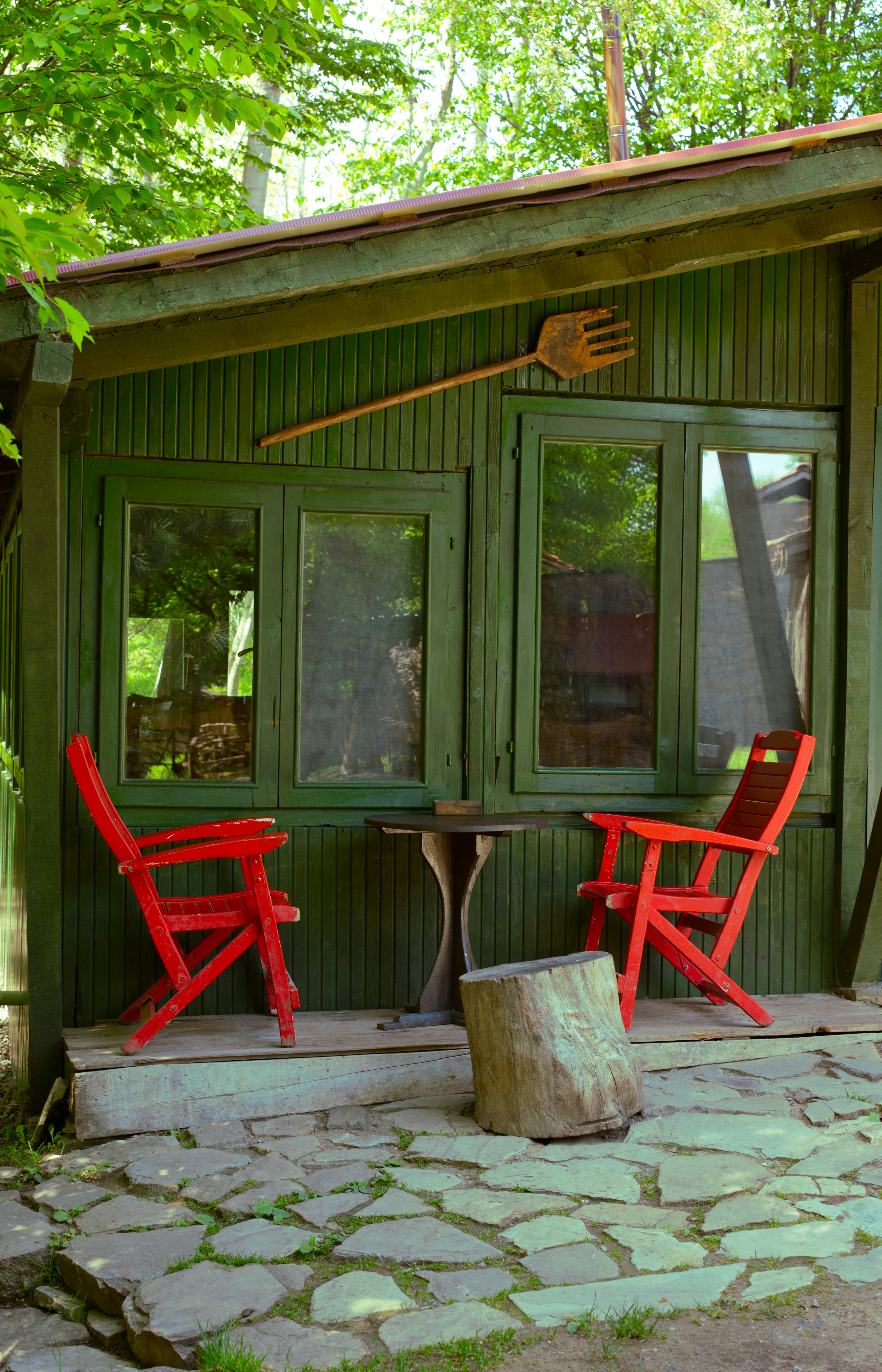 a couple of red chairs sitting in front of a green building