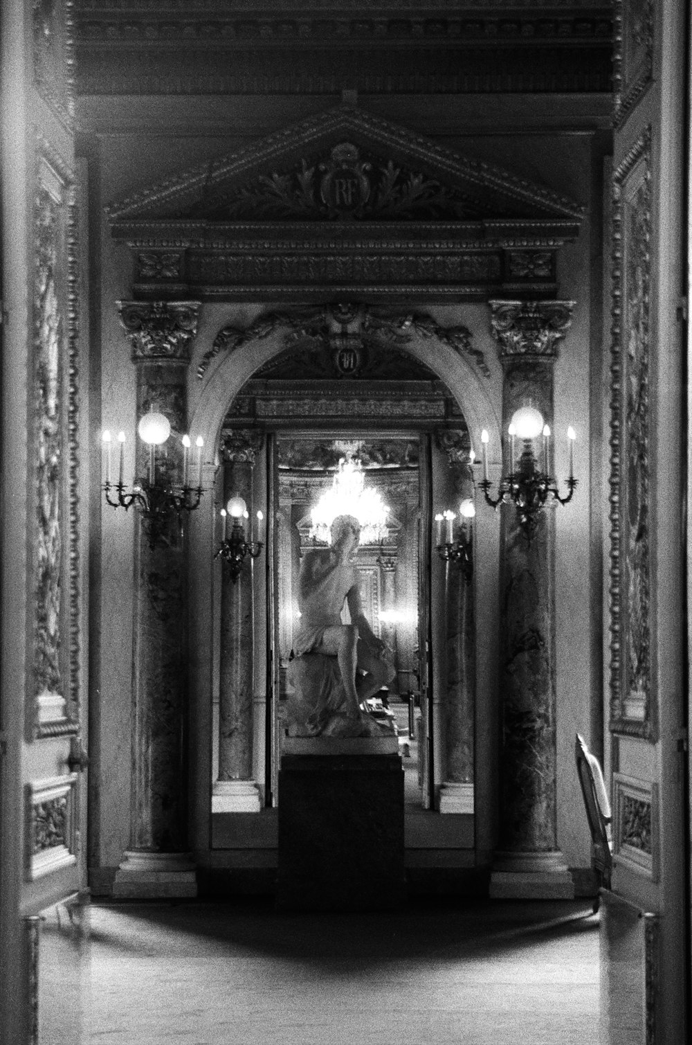 a black and white photo of a statue in a building
