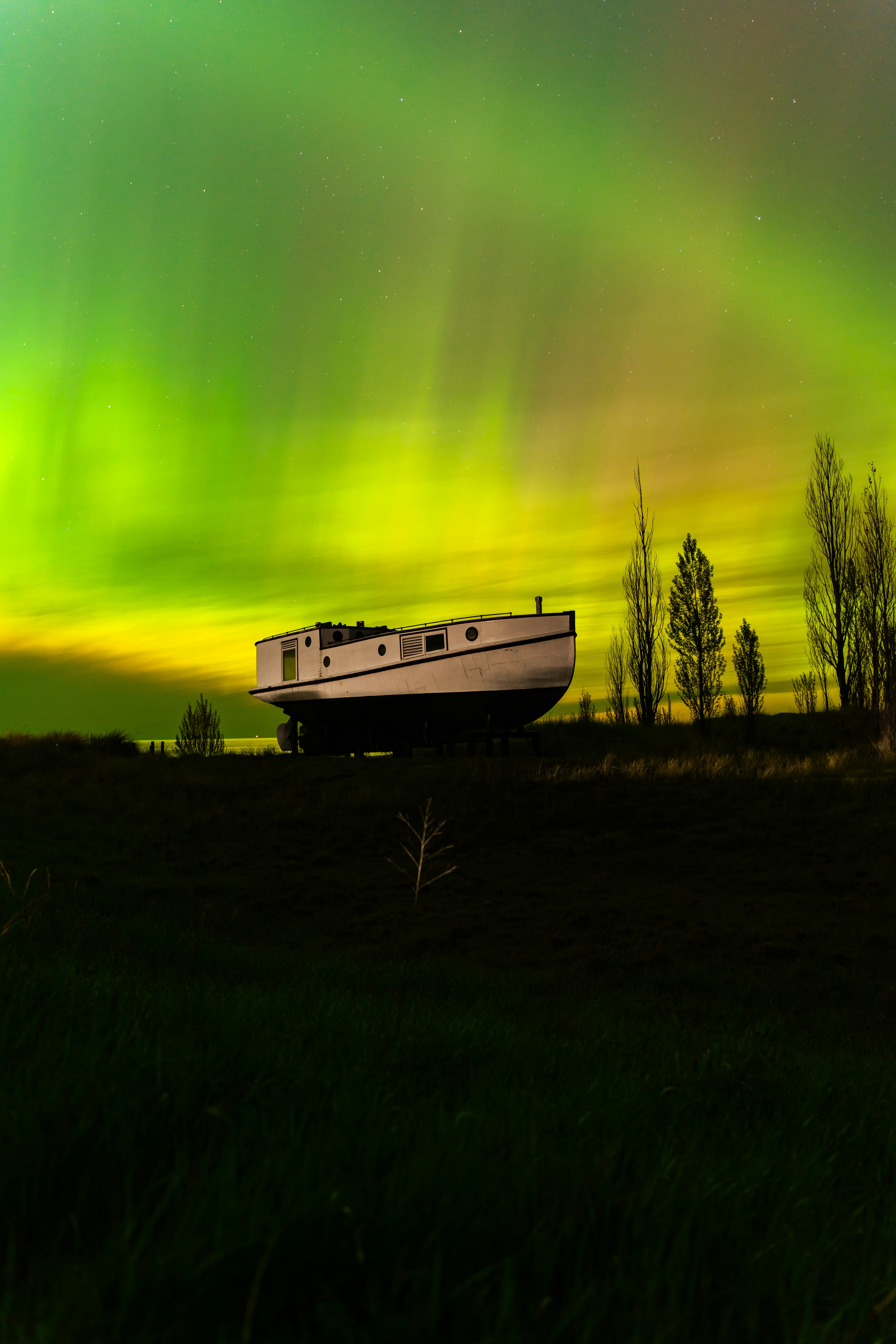 a boat sitting on top of a lush green field