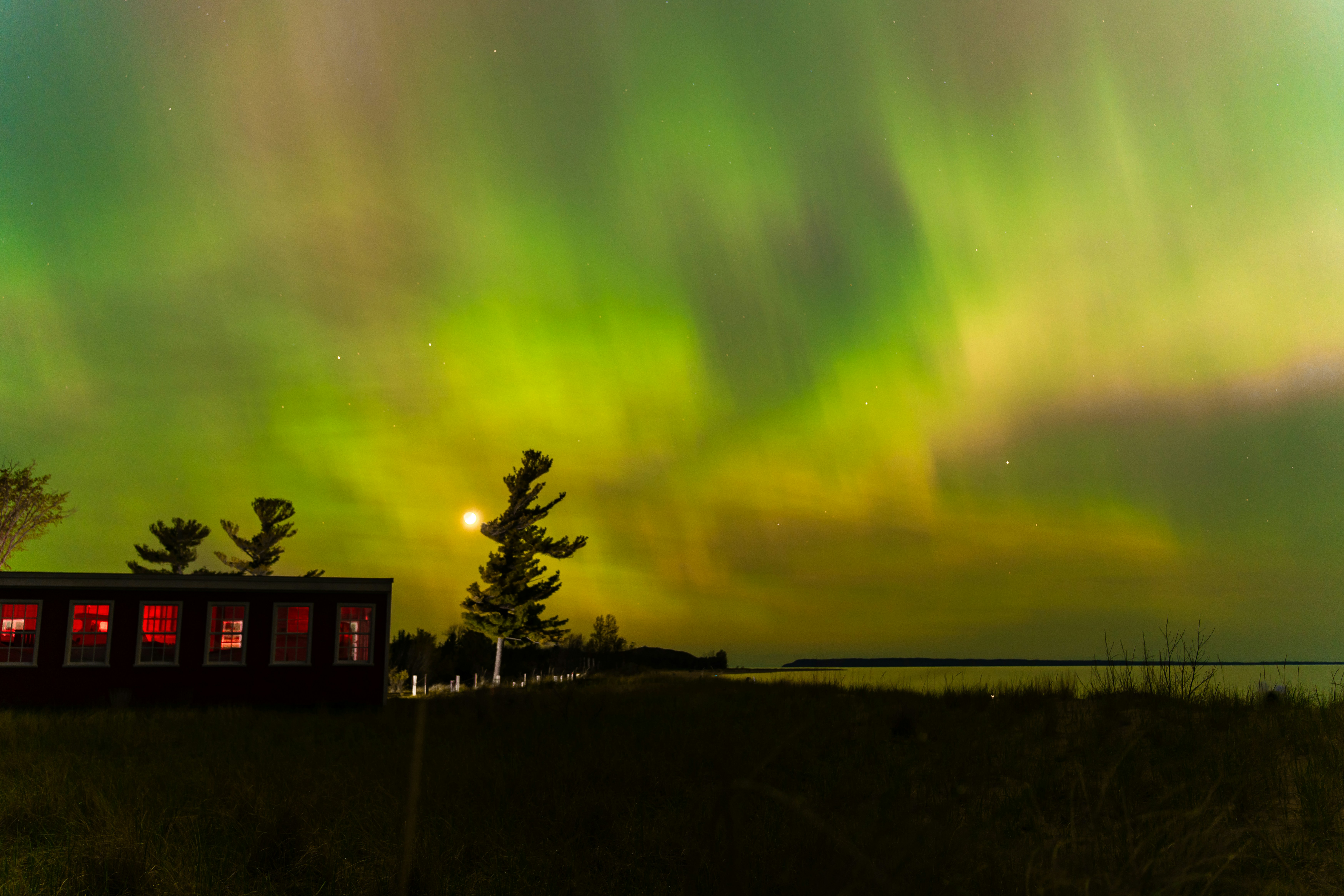a green and purple aurora bore is in the sky