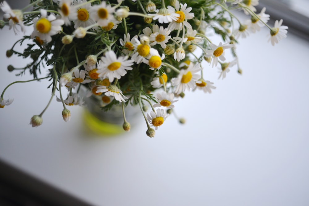 a vase filled with white and yellow flowers