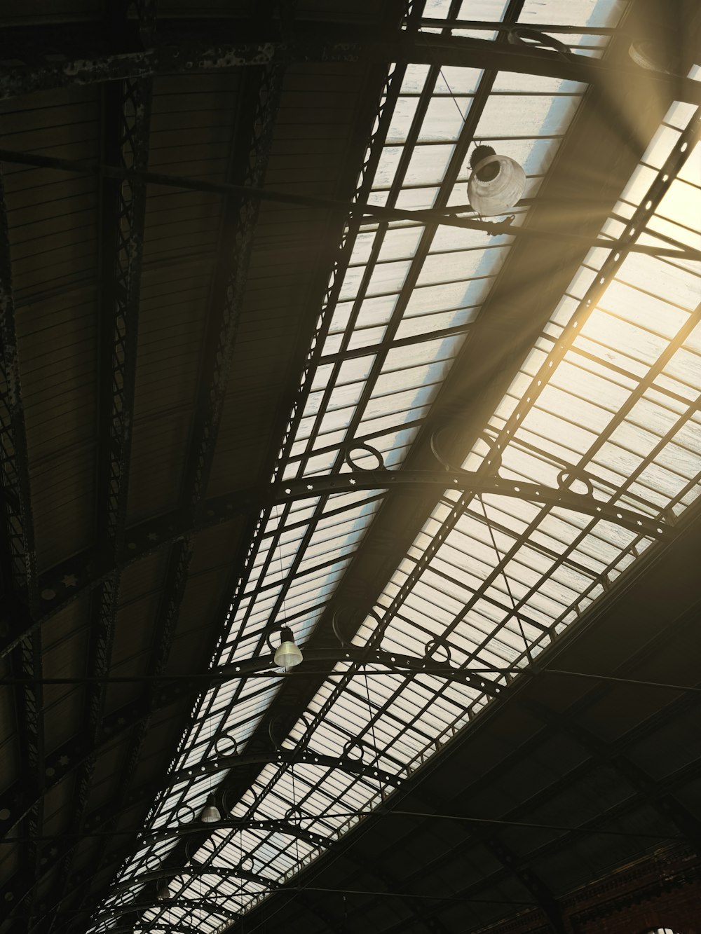 the sun is shining through the roof of a train station