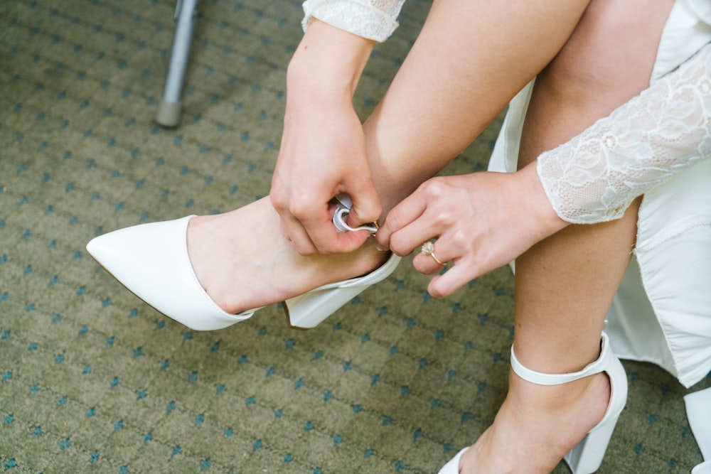 a woman putting on her wedding shoes