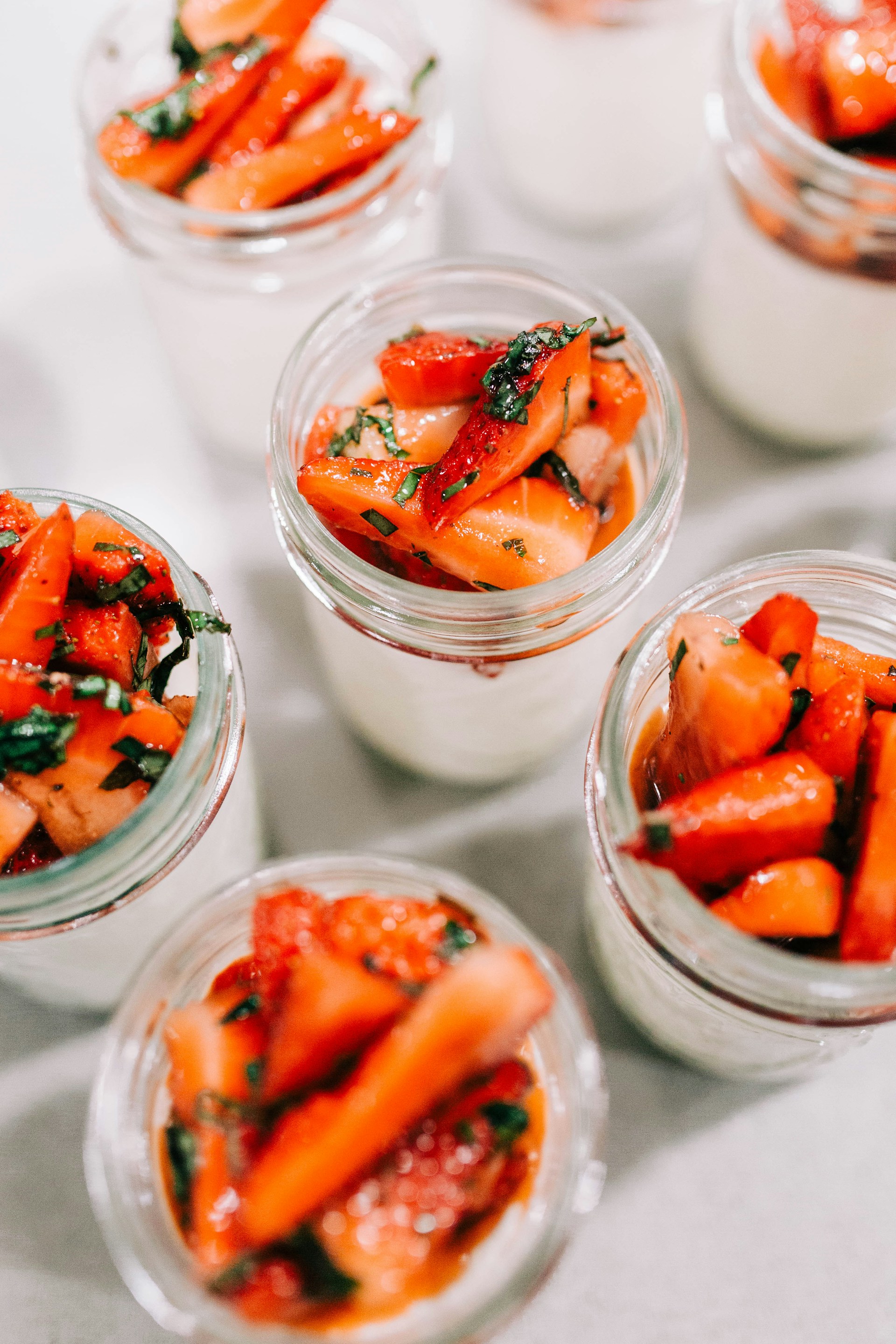 a table topped with small glass jars filled with food