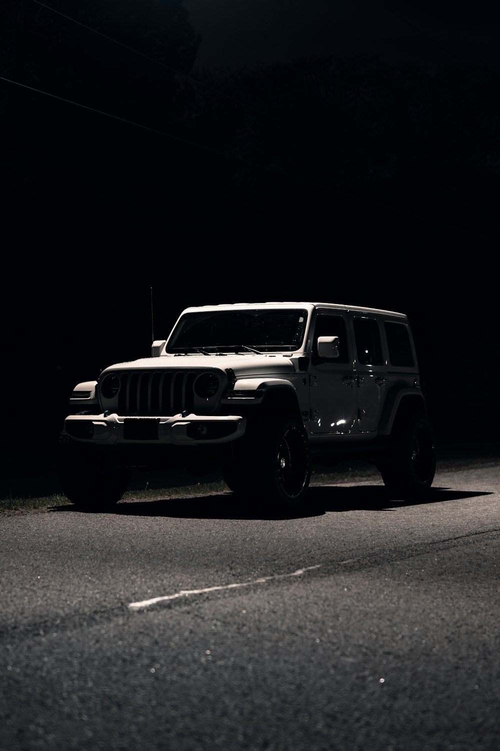 a white jeep parked on the side of a road