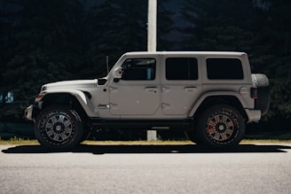 a white jeep parked on the side of the road