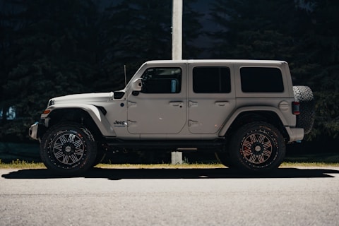 a white jeep parked on the side of the road