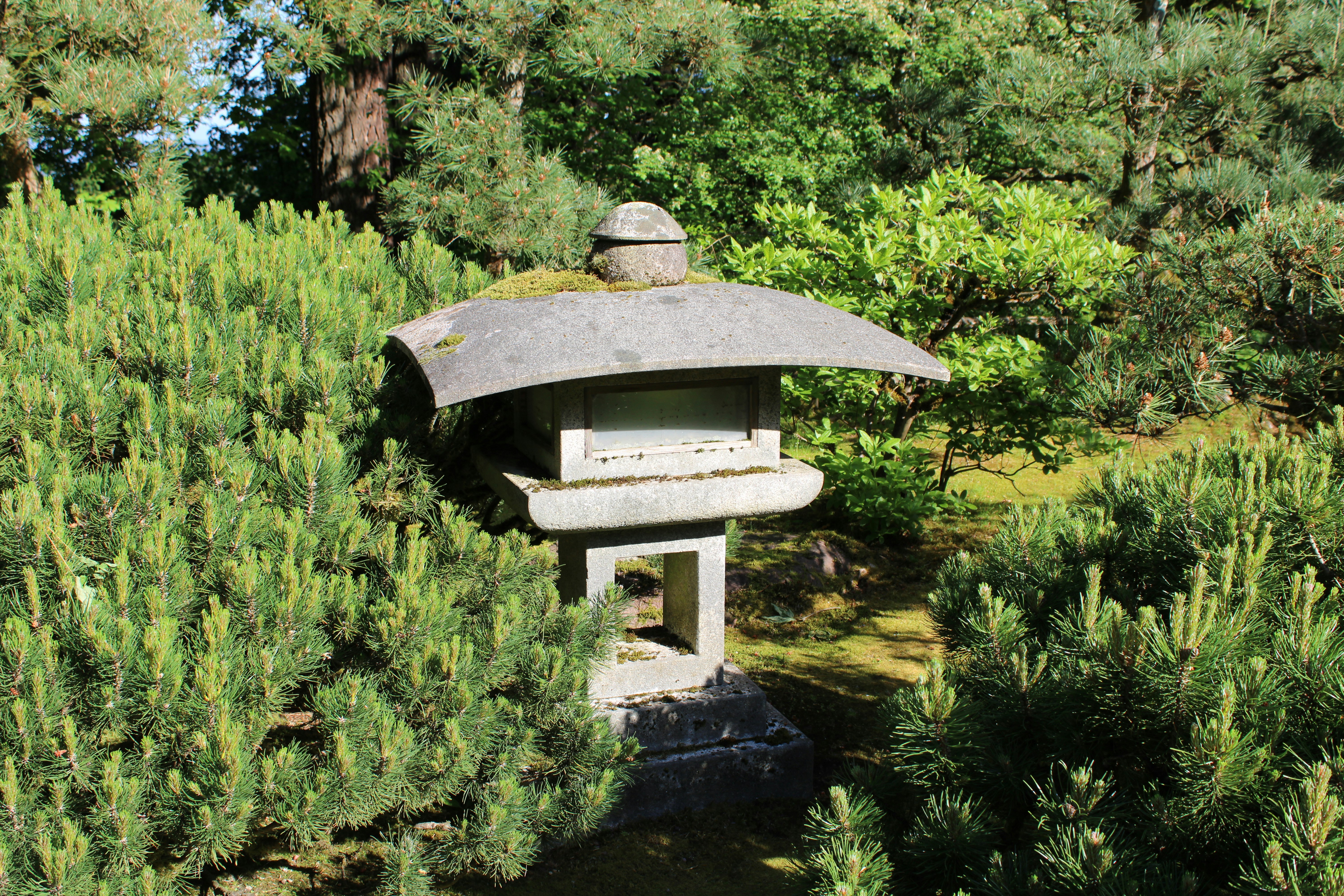 a stone lantern in the middle of a garden