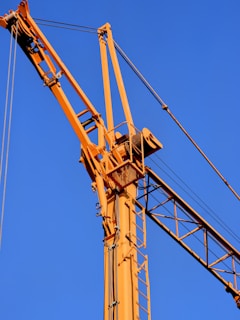 a yellow crane with a blue sky in the background