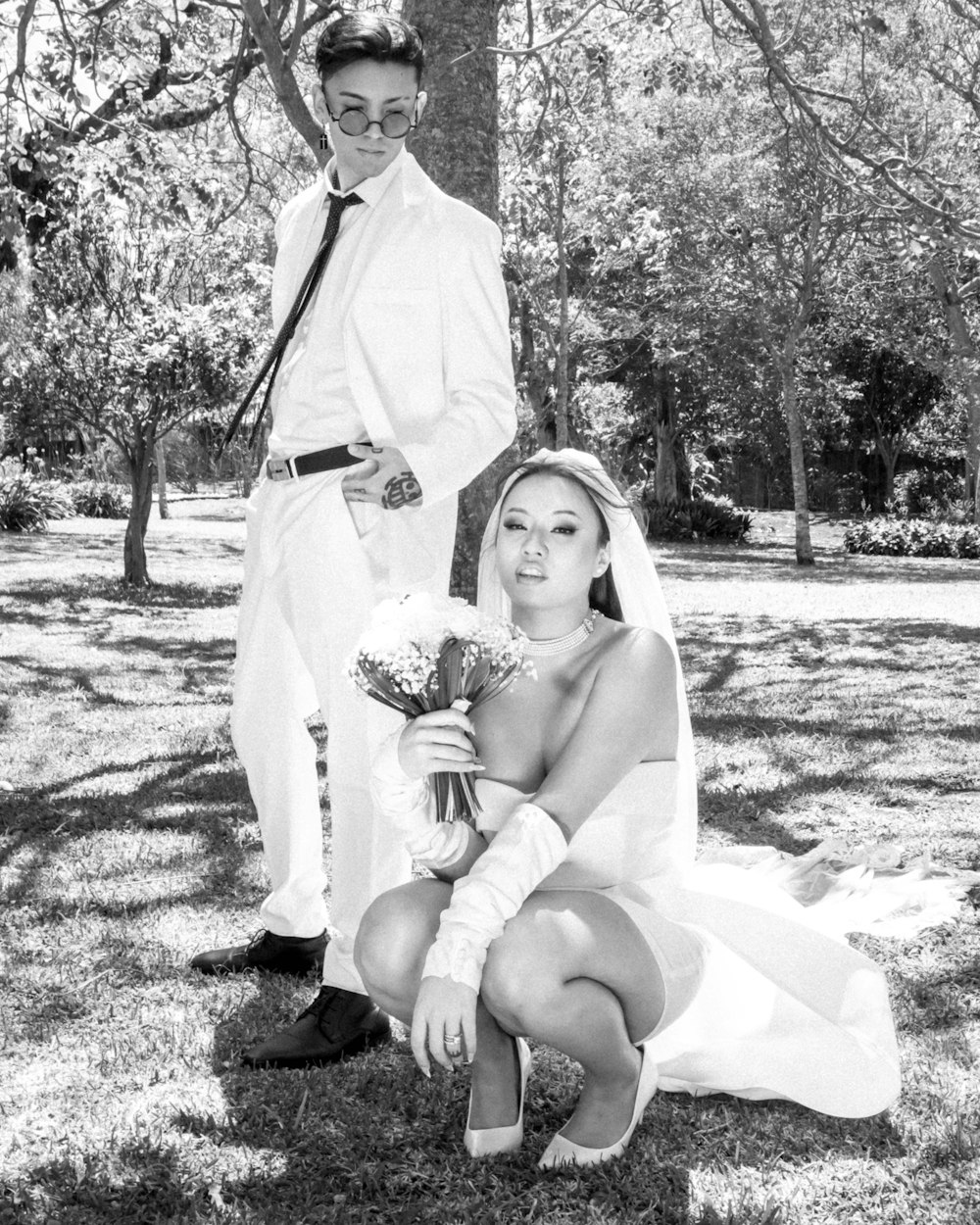 a bride and groom pose for a picture in a park