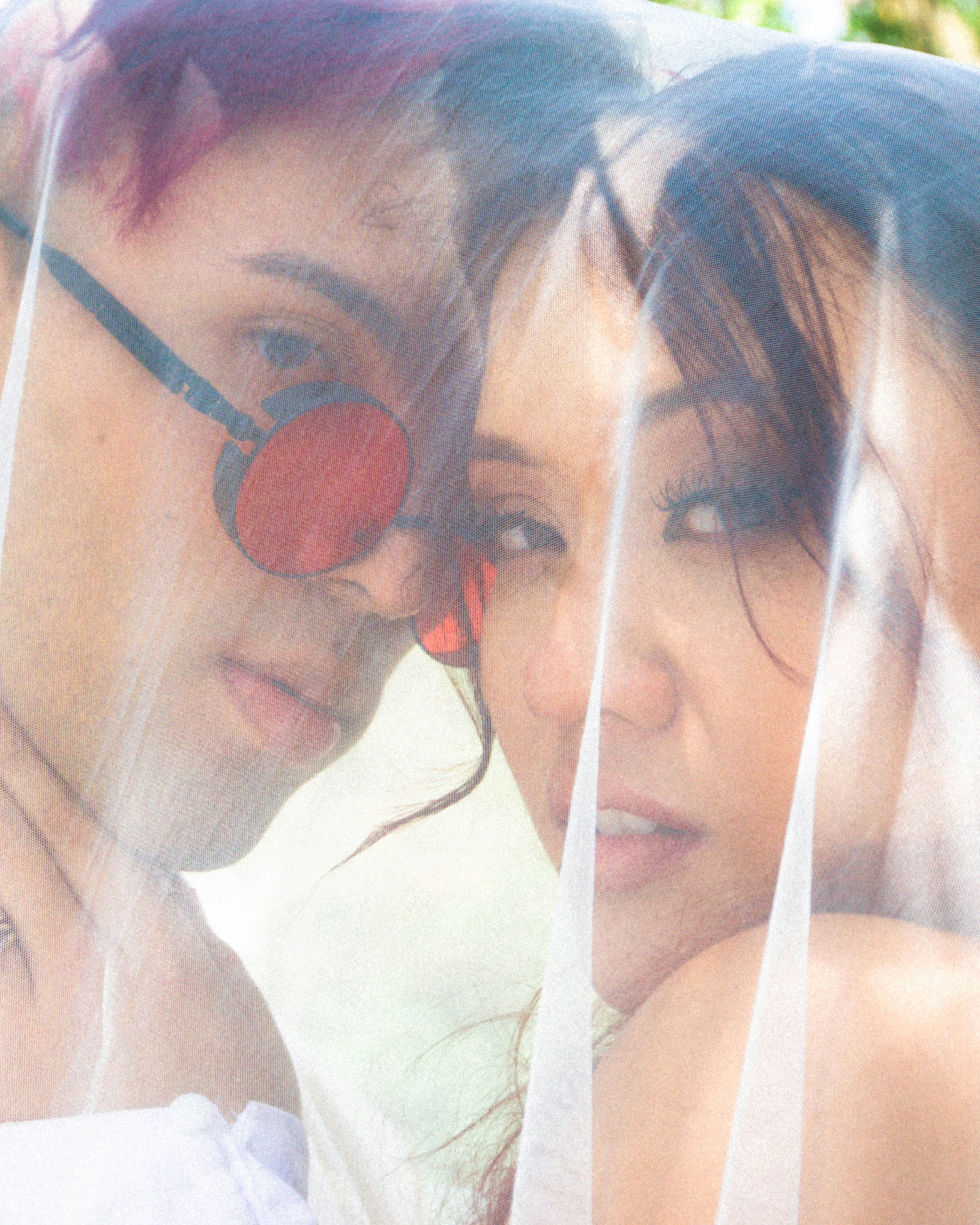 um par de pessoas que estão sob um véu