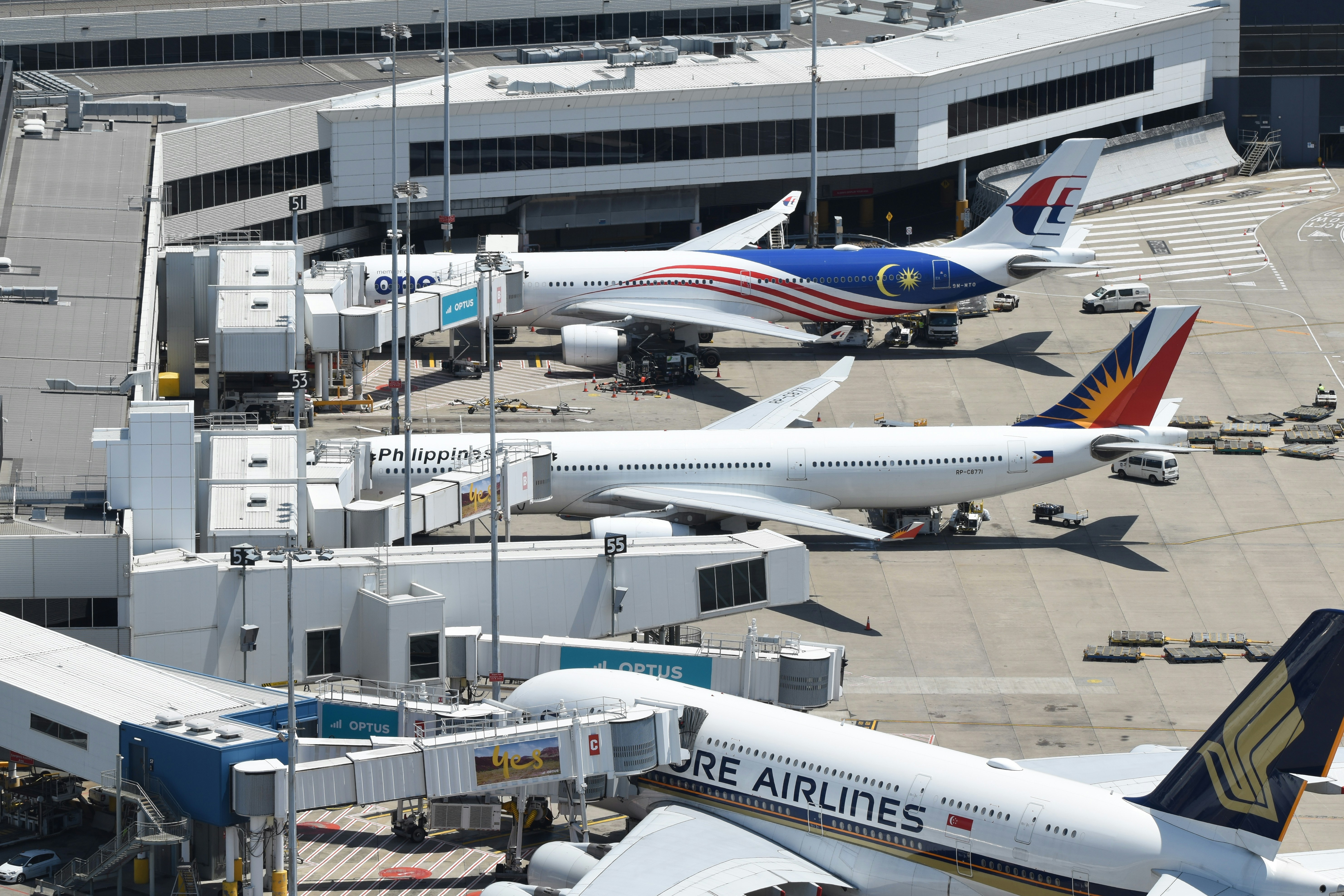 several airplanes are parked at an airport terminal, Terminal 1 at Sydney Airport