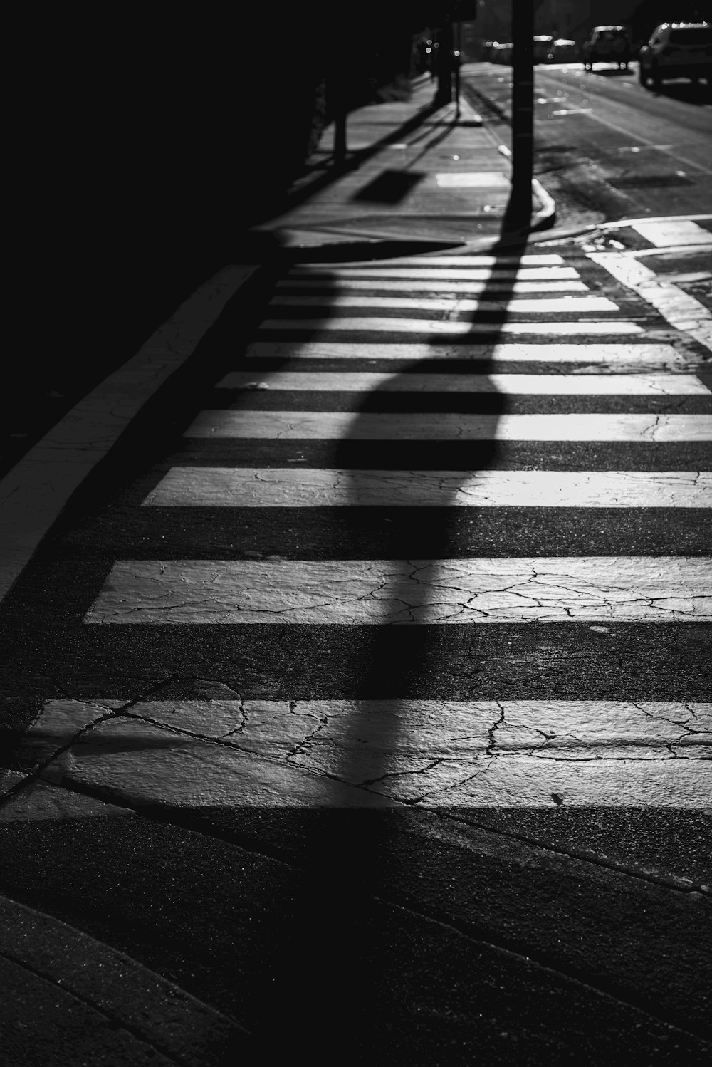 a shadow of a person walking across a street