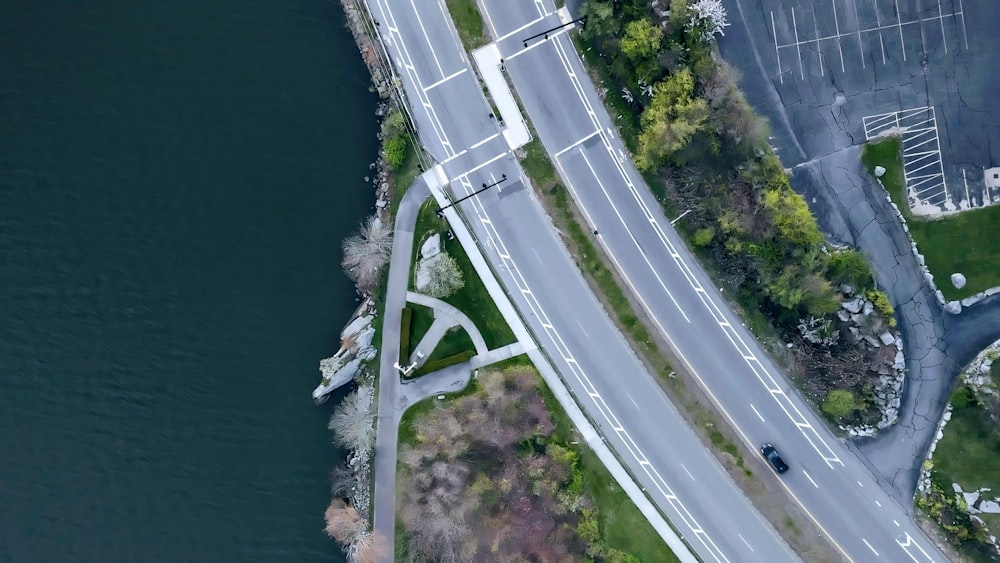 an aerial view of a road near a body of water