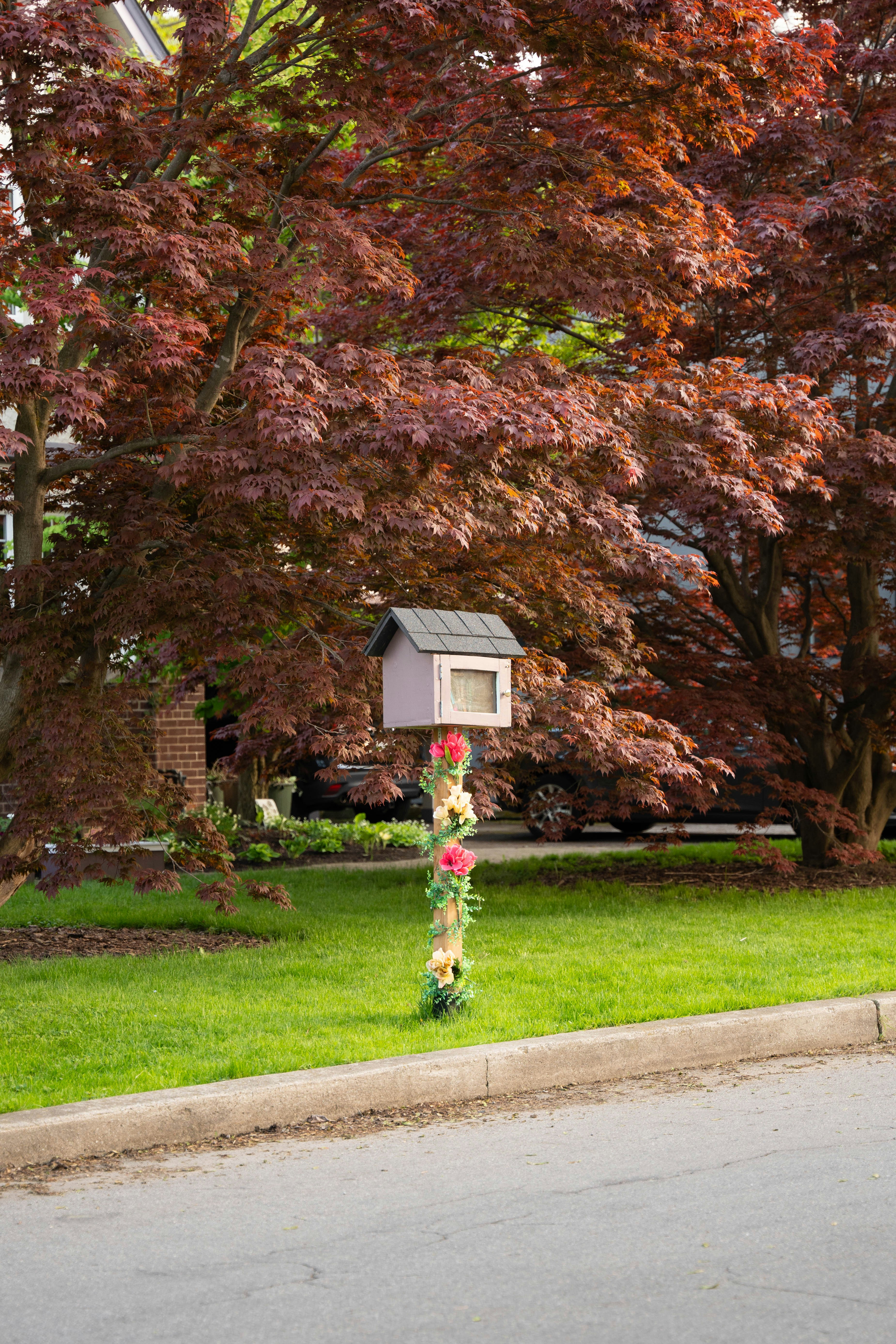 a bird house in the middle of a green lawn