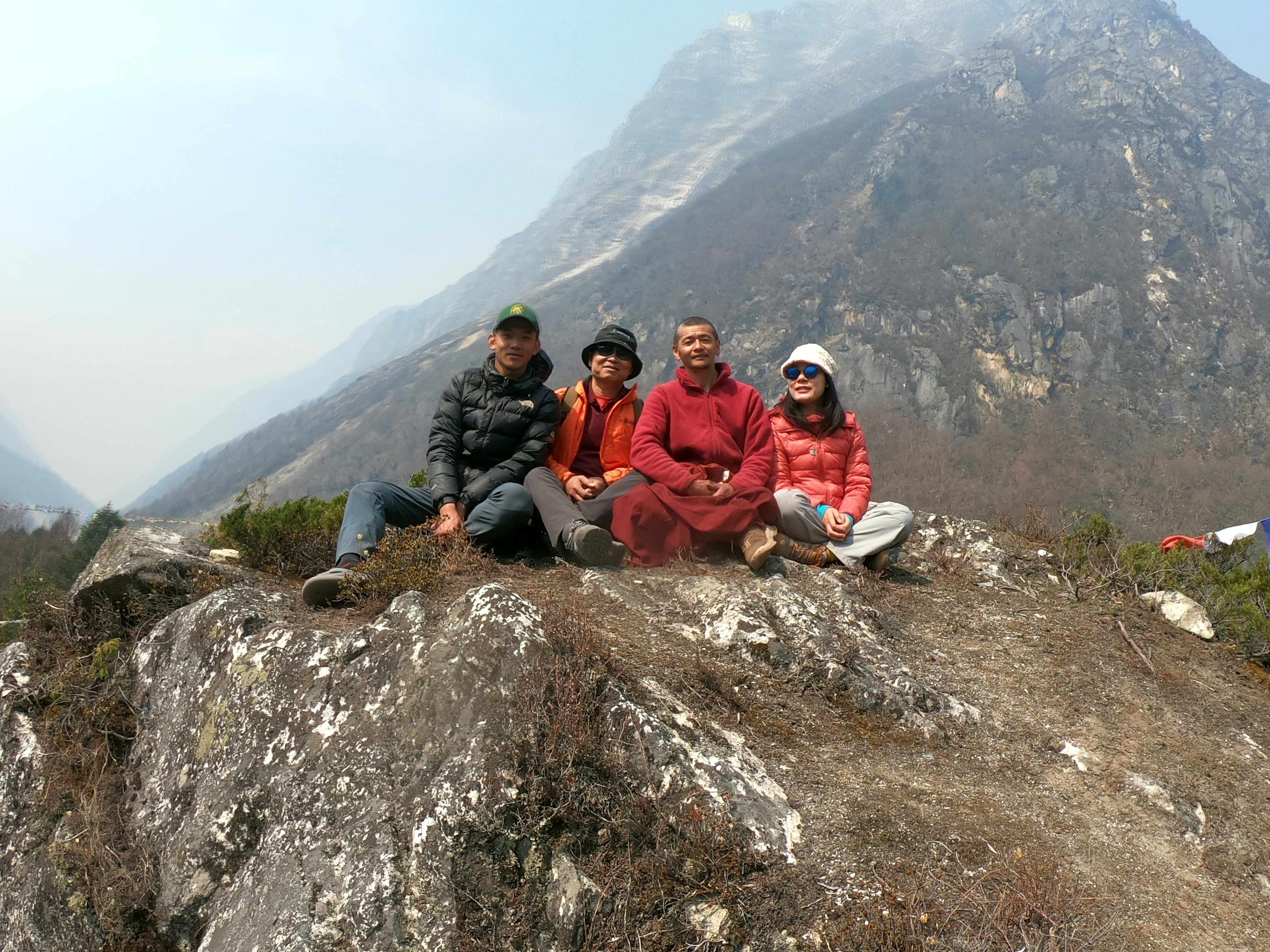 a group of people sitting on top of a mountain