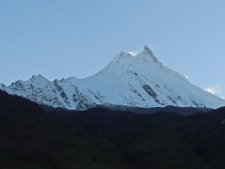 a snow covered mountain is seen in the distance