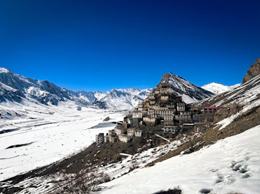 a snow covered mountain with a village on top of it