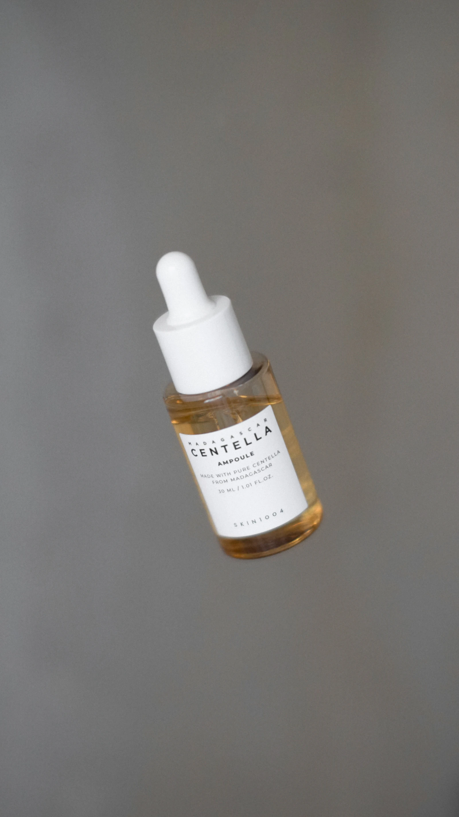 Close-up of a skincare ampoule bottle with dropper, a product used in aesthetic treatment protocols