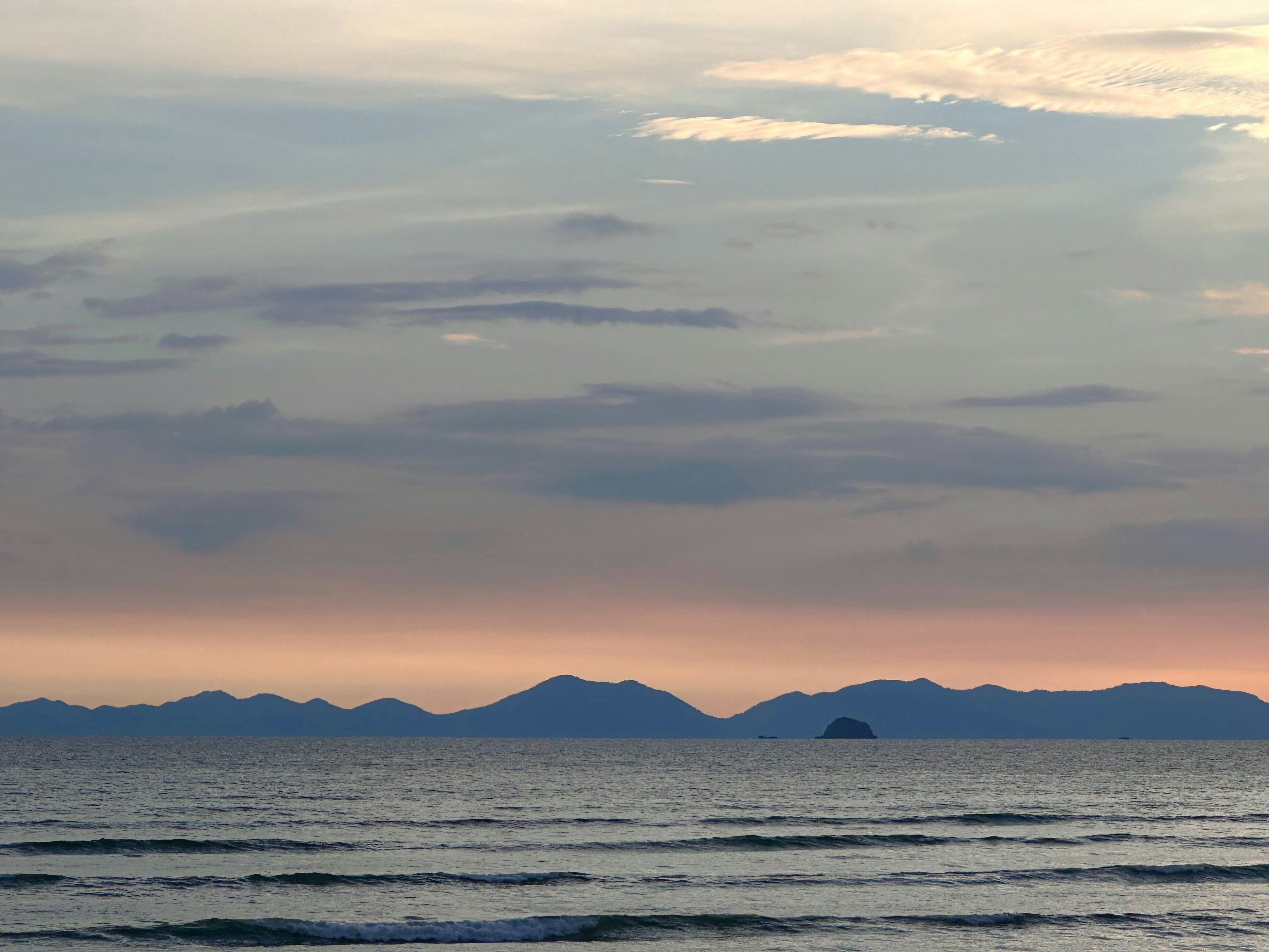 a large body of water with mountains in the background
