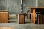 a group of wooden tables and stools in a room