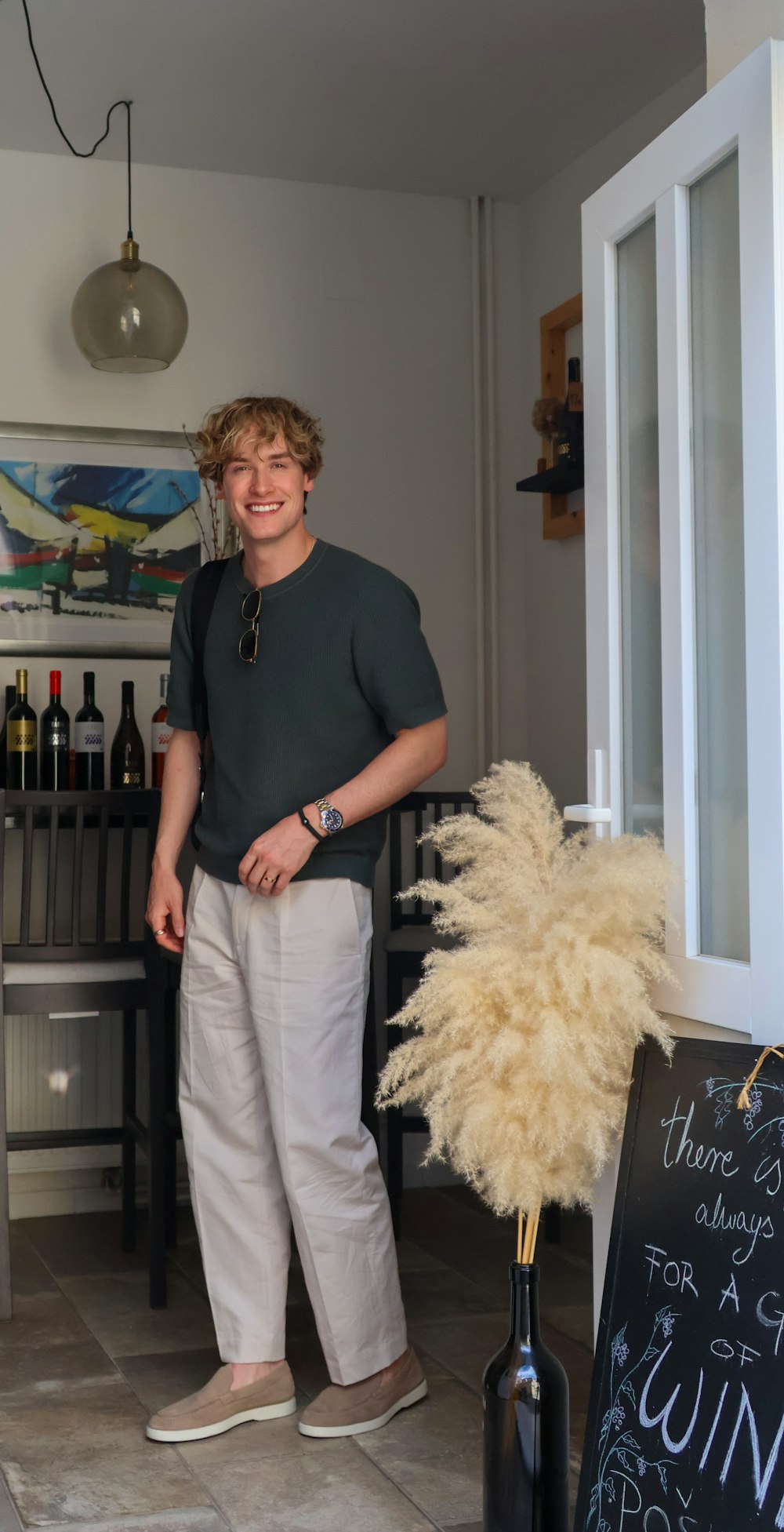 a man standing next to a bottle of wine