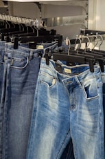 several pairs of jeans hanging on a rack