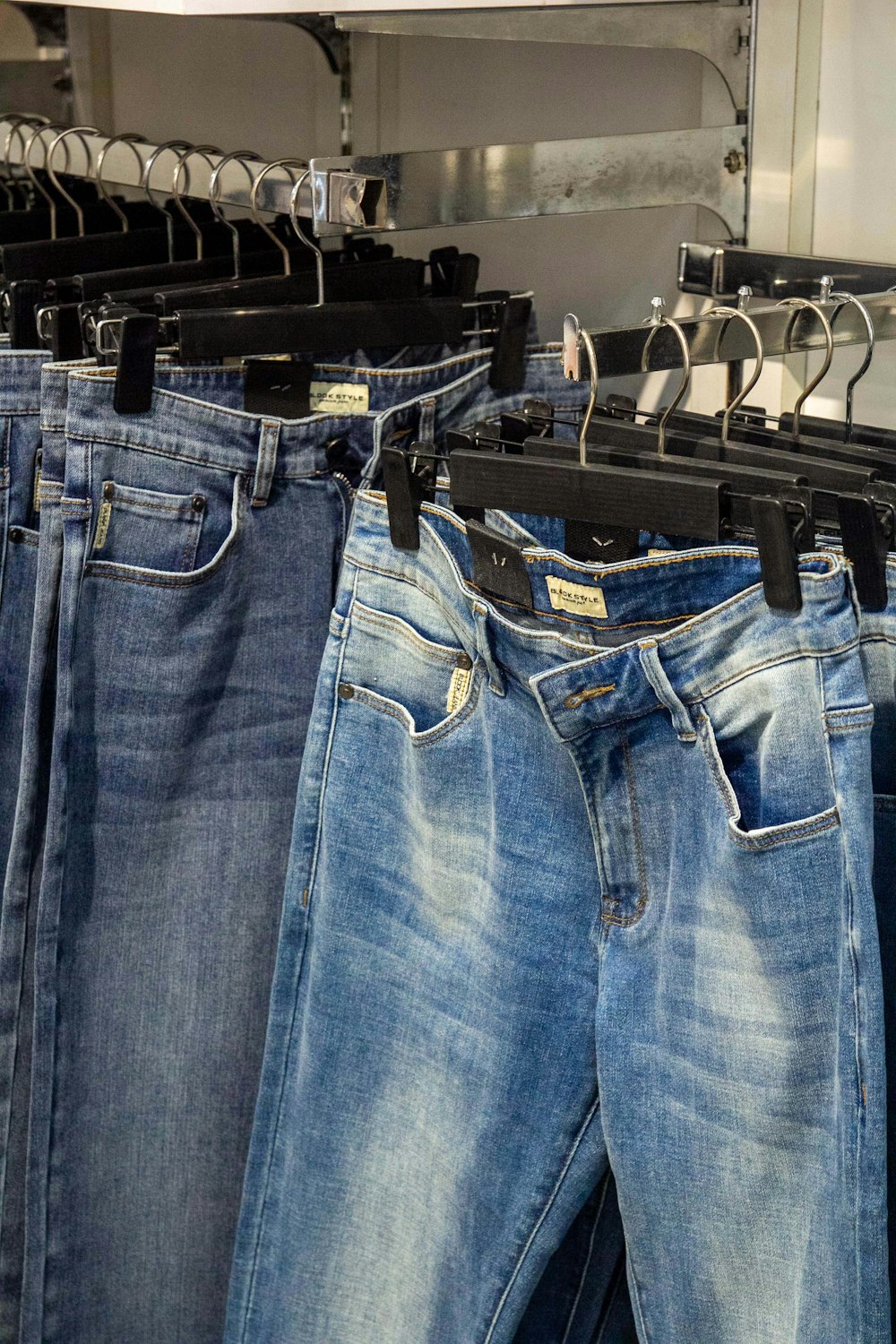 several pairs of jeans hanging on a rack