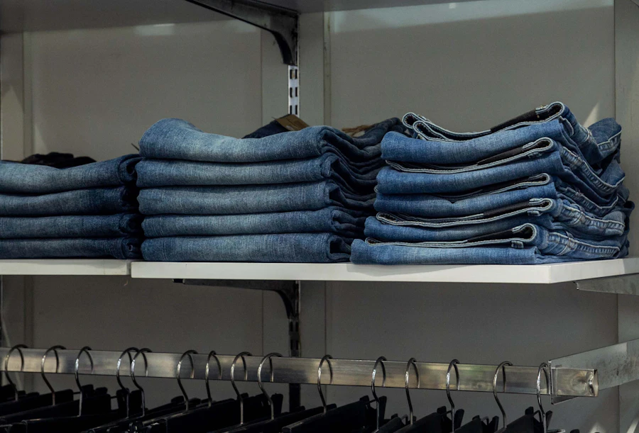 Folded slim-fit blue jeans stacked on a wholesale shelf