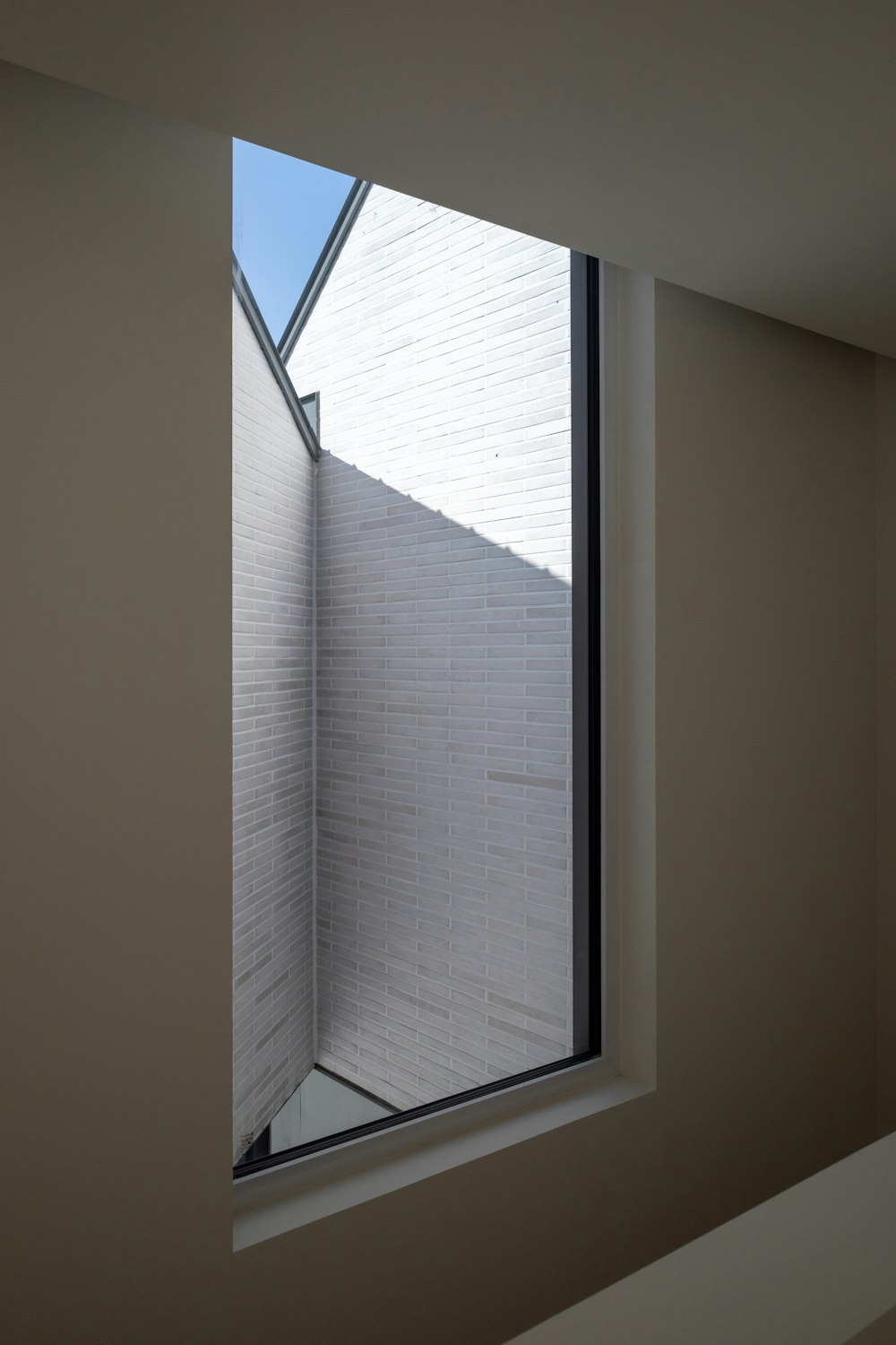 a room with a window and a white wall