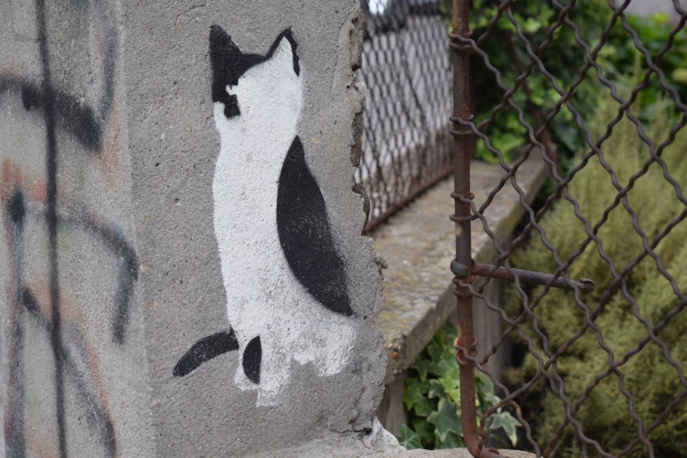 a cat painted on the side of a concrete wall