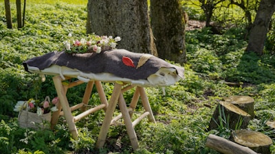 a wooden bench with a flower pot on top of it