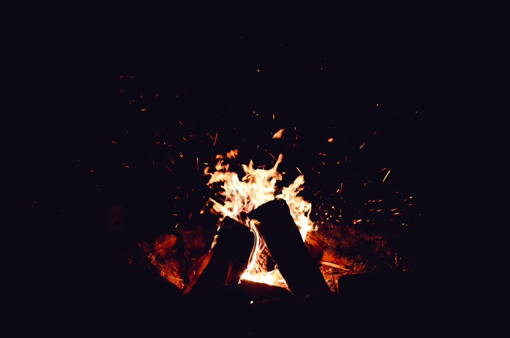 a person sitting in front of a fire in the dark