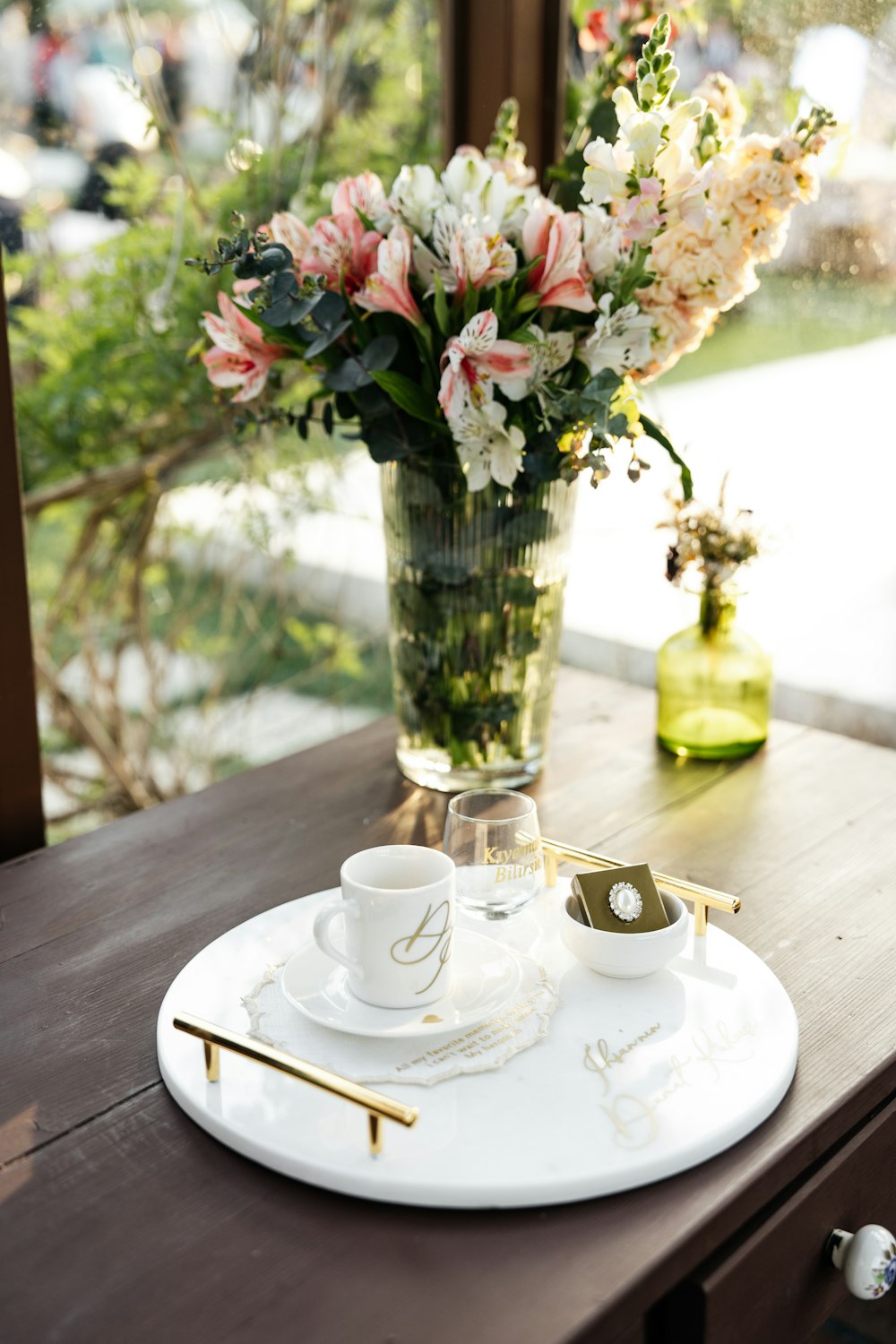 a table with a vase of flowers and two cups on it