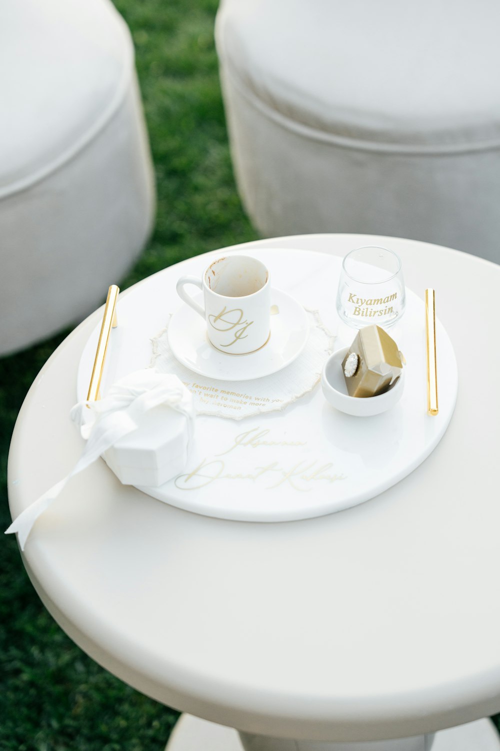 a white table topped with a cup and saucer
